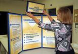 A staff member assembles a tri-fold display in Copy & Design Services