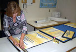 A staff member trims a tri-fold display in Copy & Design services