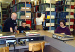 A staff member helps a student find a specific arrangement in the Music Library