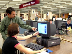 Reference Services - 1st floor Library; student receiving assistance at computer terminal